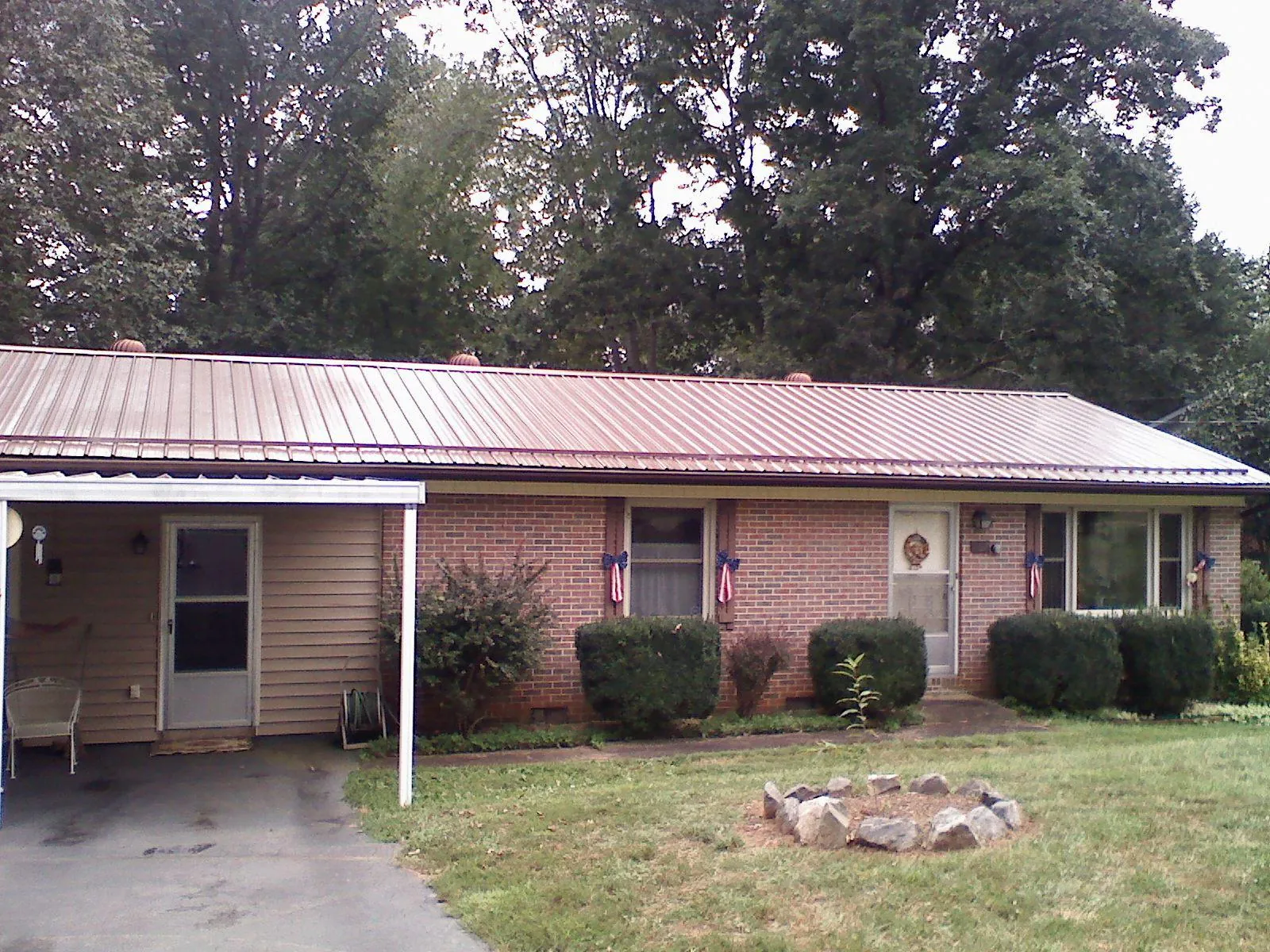 Bronze metal roof and carport on a brick ranch home — Roof Repair work by our crew in Martinsburg